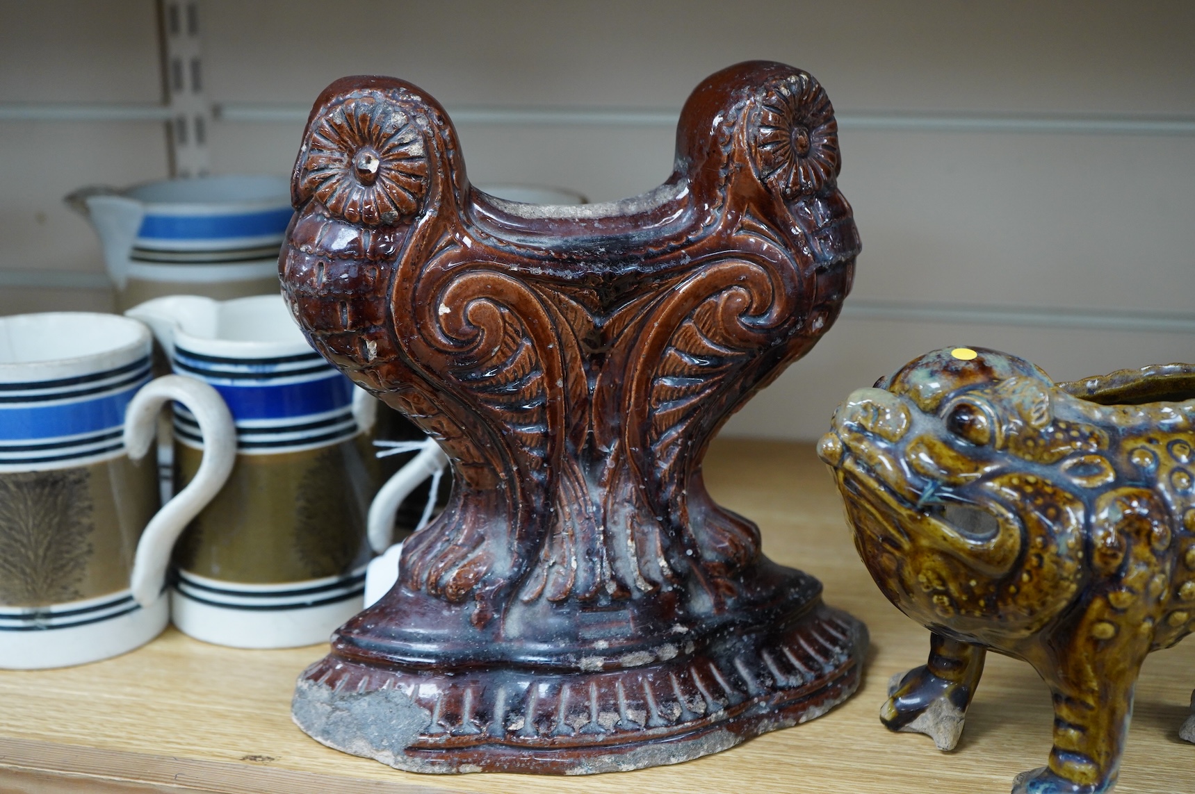 A late 19th century glazed pottery grotesque three legged toad spoon warmer in the manner of Dunmore or Burmantofts, and a Doulton owl andiron, largest 24cm high